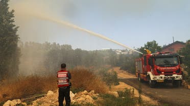 A fire-fighting plane disperses fire retardant as it assists in extinguishing a fire near Kibbutz Maale Hahamisha in Israel, in the outskirts of Jerusalem June 9, 2021. REUTERS/Ronen Zvulun
