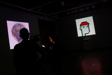 A television crew is seen next to the non-fungible token (NFT) “CryptoPunk #7523,”a series of 10,000 unique pixel-art characters made by Larva Labs in 2017, during a media preview for the “Natively Digital: A Curated NFT Sale” auction at Sotheby's in New York City, US, on June 4, 2021. (Reuters)