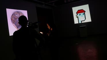 A television crew is seen next to the non-fungible token (NFT) “CryptoPunk #7523,”a series of 10,000 unique pixel-art characters made by Larva Labs in 2017, during a media preview for the “Natively Digital: A Curated NFT Sale” auction at Sotheby's in New York City, US, on June 4, 2021. (Reuters)