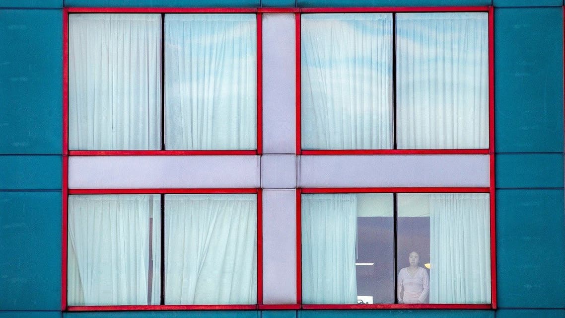A person looks out of a window at a quarantine hotel, as part of Canada's new measures against the coronavirus disease (COVID-19), which require a short stay at a government approved hotel near Toronto Pearson International Airport in Mississauga, Ontario, Canada February 24, 2021. (Reuters)