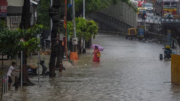A woman walks on a flooded road during heavy monsoon rains in Mumbai on June 9, 2021.. (File Photo: AFP)