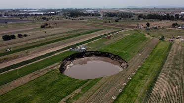 A water-filled sinkhole grows on a farming field in Zacatapec, on the outskirts of Puebla, Mexico, Tuesday, June 1, 2021. Authorities say an underground river is responsible. (AP)