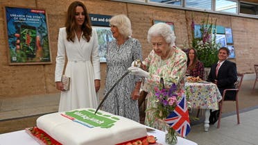 Britain's Queen Elizabeth attempts to cut a cake with a sword next to Camilla, Duchess of Cornwall, and Catherine, Duchess of Cambridge as they attend a drinks reception on the sidelines of the G7 summit, at the Eden Project in Cornwall, Britain June 11, 2021. (Reuters)