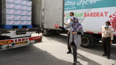 Workers are seen next to a truck loaded with Boxes of the COV Iran Barekat vaccine at the Barekat vaccine production center at the Organization of the Execution of Imam Khomeini's Order in Karaj, Iran. (Reuters)