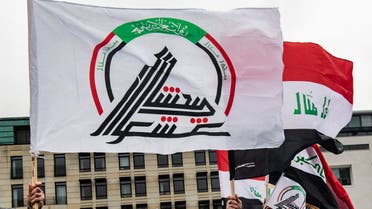 Protesters wave a flag with the insignia of the Popular Mobilization Forces (PMF), also known as the People's Mobilization Committee (PMC) and the Popular Mobilization Units (PMU), during a demonstration in front of the US embassy in Berlin on January 4, 2020. Demonstrators from different groups protested against the US attack from January 3, 2020 on Iraq's capital Baghdad International Airport, in which Iran's Major General Qasem Soleimani and nine other victims were killed. The US drone attack sparked fears of a regional proxy war between Washington and Tehran.
