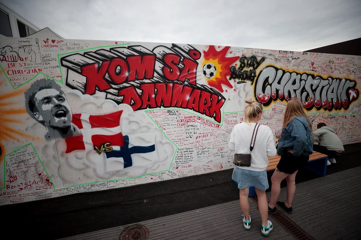 People write get well messages on a wall at a fanzone in Copenhagan on June 14, 2021, after Denmark’s Christian Eriksen collapsed on the pitch during his side's Euro 2020 match with Finland. (Reuters)