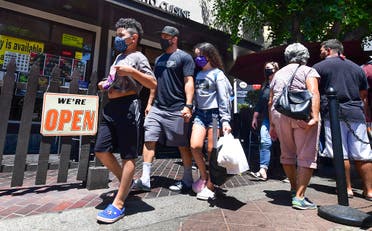 Face masks continue to be worn as people walk past restaurants open for business in Los Angeles on June 14, 2021. (Frederic J. Brown/AFP)