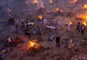 People wait to cremate victims who died due to complications related to the coronavirus disease (COVID-19), at a crematorium ground in New Delhi, India, April 23, 2021. (Reuters)