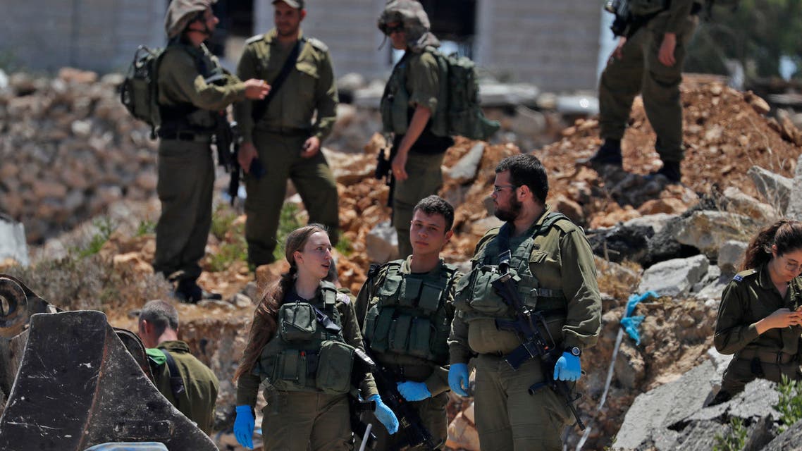 Israeli security forces gather at the scene of an attempted car-ramming and stabbing attack in the West Bank village of Hizma, near Jerusalem, on June 16, 2021. (AFP)