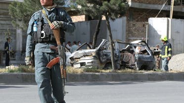An Afghan police keeps watch while other security forces inspect the wreckage of a passenger van after a blast in Kabul, Afghanistan June 12, 2021. (File photo: Reuters)