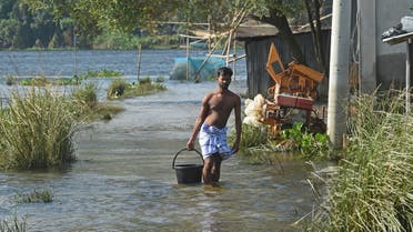 A flood-affected resident makes his way through a flooded village in Savar on August 19, 2020. (AFP)