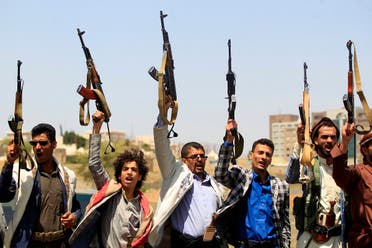 Yemeni fighters loyal to the Iran-backed Houthis raise their weapons during a rally in the capital Sanaa, on May 20, 2021. (AFP)