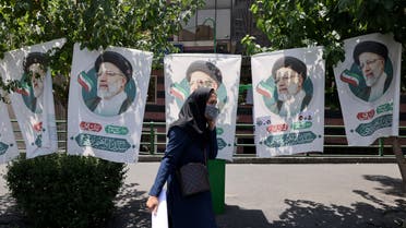 An Iranian woman walks past banners of ultraconservative cleric and presidential candidate Ebrahim Raisi, in Tehran, on June 17, 2021, on the eve of the Islamic republic's presidential election. Iranians will vote for a new president on June 18, with seven candidates in the race. People will also elect municipal councils, while six candidates will also be chosen to join the Assembly of Experts which names, oversees and can dismiss the supreme leader.