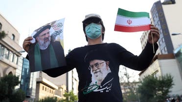 A supporter of presidential candidate Ebrahim Raisi holds a posters of him during an election rally in Tehran, Iran. (Reuters)
