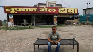 Vikas Malik, owner of a dhaba, a small restaurant, sits for a picture in front of his temporarily closed dhaba along a national highway in Murthal, in the northern state of Haryana, India, on June 17, 2021. (Reuters)