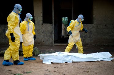 عمال صحيون ينقلون جثة متوفى بإيبولا في غينيا في 2014 (أرشيفية)