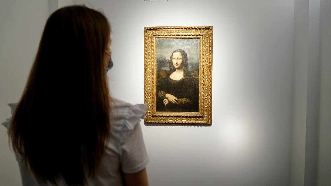 A woman looks at the Hekking Mona Lisa, a reproduction of Leonardo Da Vinci's Mona Lisa, painted on canvas by an unknown artist from the 17th century and up for an online sale at Christie’s auction house in Paris, France, June 11, 2021. REUTERS/Lucien Libert