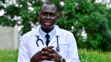  العربية Samuel Dhol Ayeun, a trainee doctor who fled from South Sudan to Uganda, poses for a photo at the Mulago National Specialised Hospital in Kampala, Uganda June 17, 2021. Picture taken June 17, 2021. REUTERS/Abubaker Lubowa