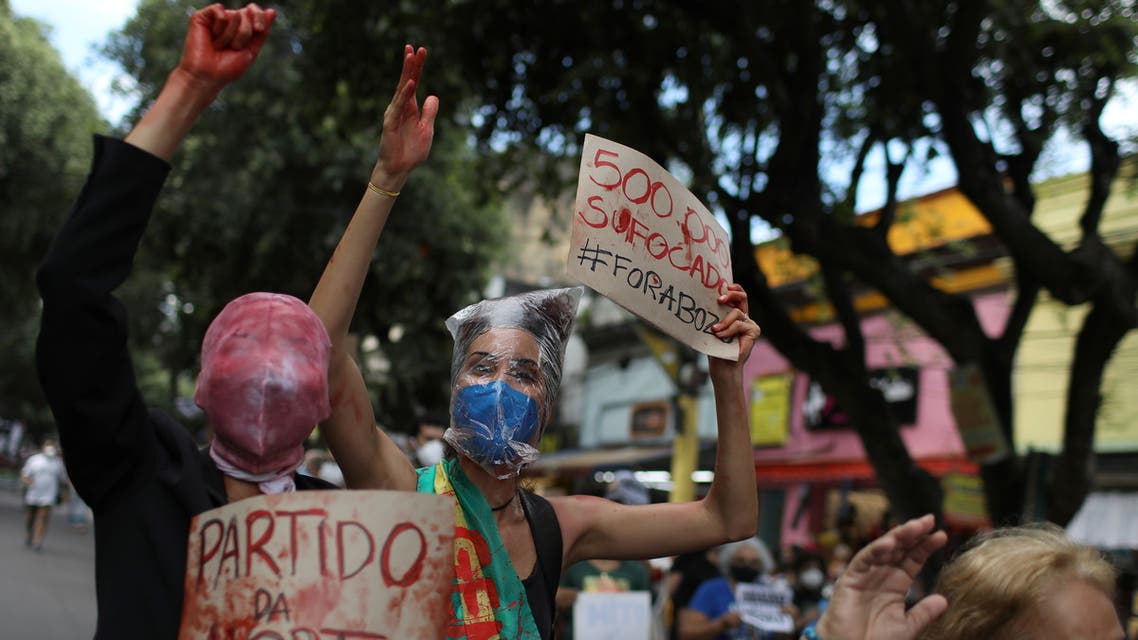 People participate in a demonstration against Brazil's President Jair Bolsonaro's handling of the coronavirus disease (COVID-19) pandemic and to impeach him, in Manaus, Brazil, June 19, 2021. The banners read “Party of Death” and “500,000 suffocated.” (Reuters)