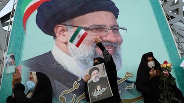 A supporter of Ebrahim Raisi displays his portrait during a celebratory rally for his presidential election victory in Tehran, Iran June 19, 2021. (Majid Asgaripour/WANA (West Asia News Agency) via Reuters)