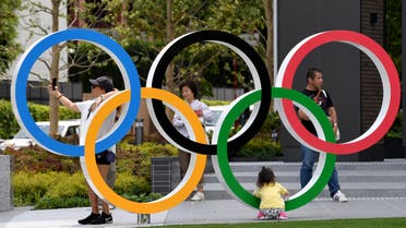 People takes photographs of the Olympic Ring at the Japan Sport Olympic Square beside the under constructing national stadium in Tokyo on May 18, 2019. (File photo: AFP)