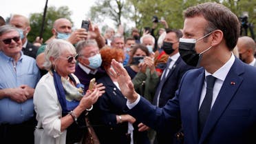 French President Emmanuel Macron (R), wearing a mask, greets voters at the polling station in Le Touquet, during the first round of the French regional elections on June 20, 2021. (Christian Hartmann/Pool/AFP)