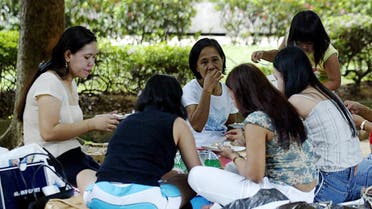 Domestic helpers enjoy a picnic in the shade at Gulung-gulung park in Singapore, 27 July 2003. Singapore's tough campaign to curb employer abuses against foreign maids has improved their working conditions, but civic activists are calling for more reforms saying various forms of indignities persist. (File photo: AFP)