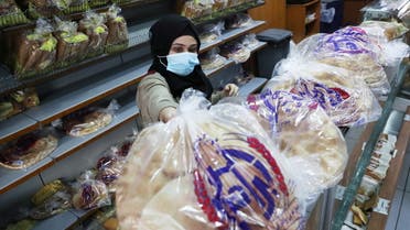 A vendor wearing a face mask arranges bread for sale inside a bakery in Beirut, Lebanon December 7, 2020. (Reuters)