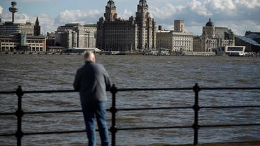 A man looks towards Liverpool's iconic waterfront property the Royal Liver building (C) across the River Mersey in Birkenhead , northern England October 17 , 2016. The 105 year old building is to be sold for the first time, for an expected 40 million pounds ($50 million). (Reuters)