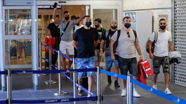 Vaccinated tourists wearing masks for COVID-19 protection arrive to Israel’s Ben Gurion Airport near Tel Aviv on May 23, 2021, after a partial re-opening of the border to inoculated tourists from 14 countries. (Jack Guez/AFP)