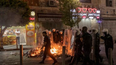 Angry demonstrators set fires, block the streets of the city center and clash with riot police following the death of Nizar Banat, an outspoken critic of the Palestinian Authority, in the West Bank city of Ramallah, on June 24, 2021. (AP)