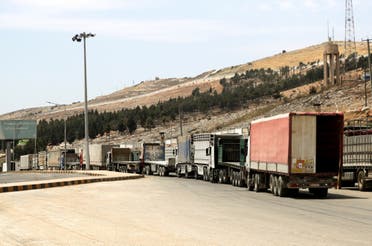 شاحنات تنتظر عند معبر باب الهوى على الحدود السورية التركية بمحافظة إدلب (أرشيفية من رويترز)