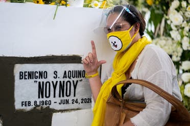 A woman flashes the 'L' sign for the Filipino word laban which means fight, following the burial of Philippine President Benigno Aquino III, at the Manila Memorial Park, in Paranaque city, Metro Manila, Philippines, June 26, 2021. (Reuters)