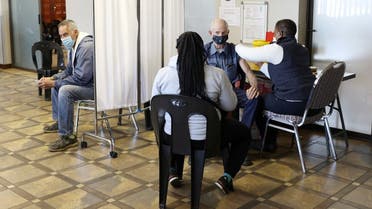 A man is vaccinated as another looks on while waiting to receive a dose of a coronavirus disease vaccine in Meyerton, south of Johannesburg, South Africa June 23, 2021. (Reuters/Siphiwe Sibeko)