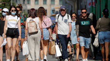 People, some without protective masks, walk downtown Madrid, as they are no longer required outdoors from June 26, amid the coronavirus disease (COVID-19) pandemic, Spain, June 26, 2021. (Reuters)