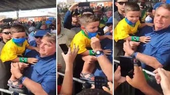 شاهد الرئيس البرازيلي ينزع الكمامة عن وجهي طفلين