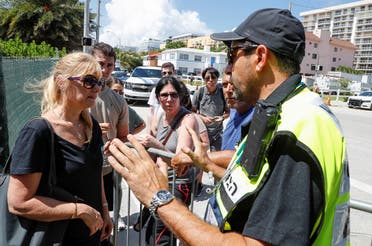 Family members of those reported missing ask Joseph Dahan (R), an EMT with Hatzalah, a volunteer emergency organization, on how to join other families to view the site of a partially collapsed residential building in Surfside, near Miami Beach, Florida, U.S. June 27, 2021. (Reuters)
