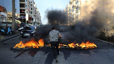 A Lebanese man sets tires on fire during a protest at a main road in Lebanon's capital Beirut against dire living conditions amidst the ongoing economical and political crisis, on June 28, 2021.