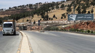 A vehicle drives past a road sign that reads Welcome to Bab al-Hawa crossing, at Bab al-Hawa crossing at the Syrian-Turkish border, in Idlib governorate, Syria June 10, 2021. Picture taken June 10, 2021. REUTERS/Khalil Ashawi