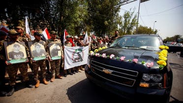 Members of Iraqi Popular Mobilization Units (PMU) carry pictures of fellow members of PMU, who were killed by US air strikes on the Syria-Iraq border, during a symbolic funeral in Baghdad, Iraq, June 29, 2021. (Reuters)