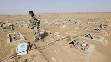 An army soldier stands next to graves of Houthi fighters in the historical town of Baraqish in Yemen's al-Jawf province after it was taken over by pro-government forces from Houthi fighters April 6, 2016. REUTERS/Ali Owidha TPX IMAGES OF THE DAY