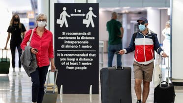 Passengers wearing protective face masks walk at Fiumicino Airport in Rome, Italy, June 30, 2020. (Reuters/Guglielmo Mangiapane)