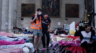 A paramedic volunteer helps a migrant on a hunger strike, occupying the Saint-Jean-Baptiste-au-Beguinage church in Brussels on June 30, 2021. (Kenzo Tribouillard/AFP)