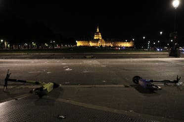 Broken glass and e-scooters are seen on a street in front of Les Invalides in Paris late on June 11, 2021, after people gathered there for an unauthorized outdoor party. (AFP)