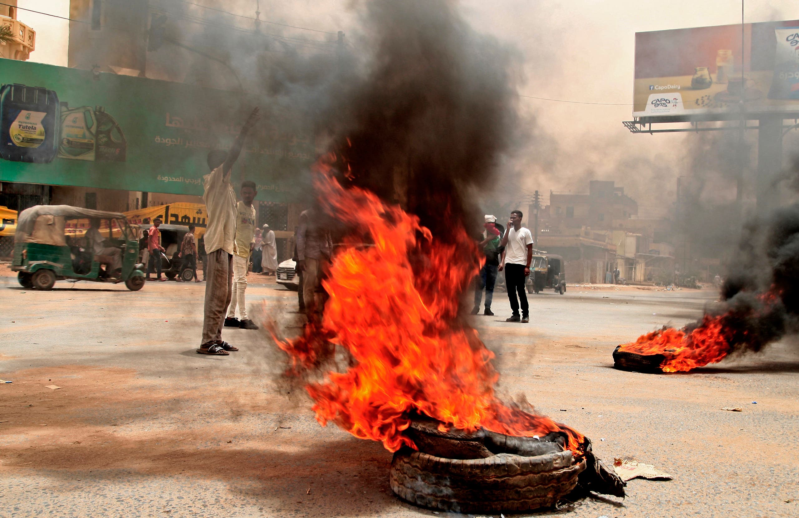 Sudanese protesters burn tires during a demonstration in Omdurman, the capital's twin city, urging the government to step down over delayed justice and recent harsh economic reforms, on June 30, 2021. (AFP)