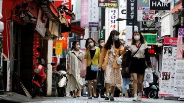 People wearing masks walk at Myeongdong shopping district amid social distancing measures to avoid the spread of the coronavirus disease, in Seoul, South Korea. (Reuters)