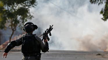 A member of the Israeli security forces runs with a weapon during clashes with Palestinian stone throwers at the entrance of the northern village of Qusra in the occupied West Bank near Nablus on December 4, 2017. An Israeli settler shot dead a Palestinian in the occupied West Bank last week after a group of Israelis was targeted by Palestinian stone-throwers, officials said.