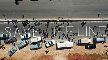A human chain is formed calling for maintaining a UN resolution authorizing the passage of humanitarian aid into Idlib through the Bab al-Hawa border crossing with Turkey on July 2, 2021. (AFP)