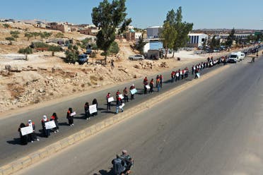 A human chain is formed calling for maintaining a UN resolution authorizing the passage of humanitarian aid into Idlib through the Bab al-Hawa border crossing with Turkey on July 2, 2021. (AFP)