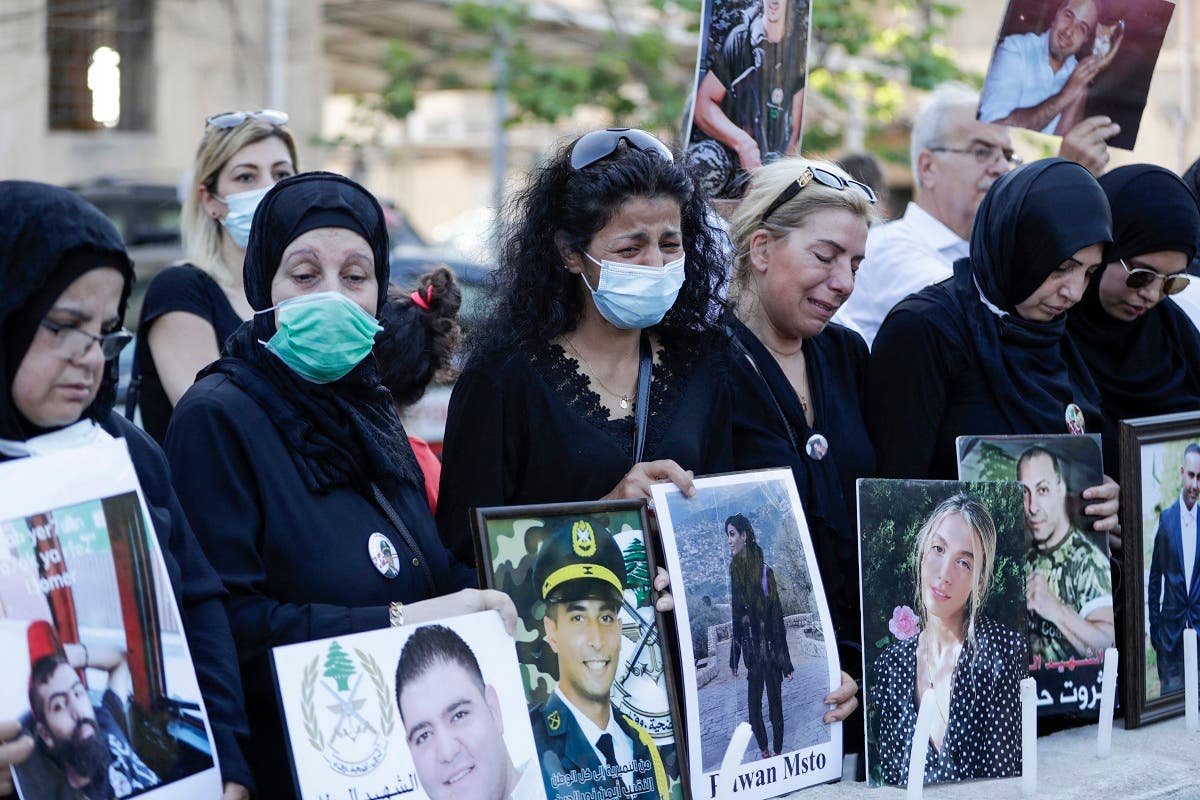 Relatives of victims of Beirut’s port blast hold their pictures as they rally in the Lebanese capital on July 4, 2021. (Anwar Amro/AFP)